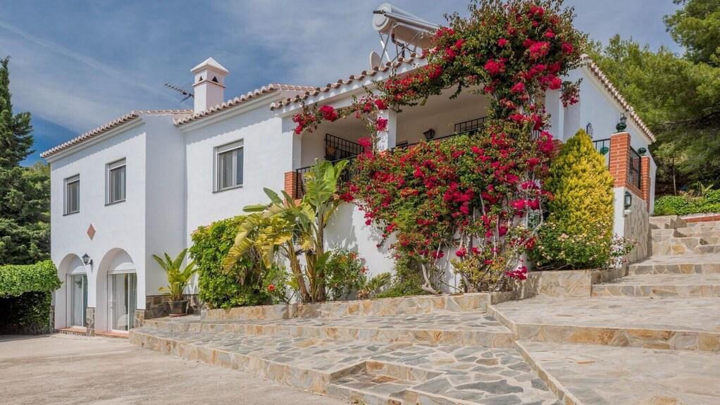 Traditional Andalusian house surrounded by greenery.